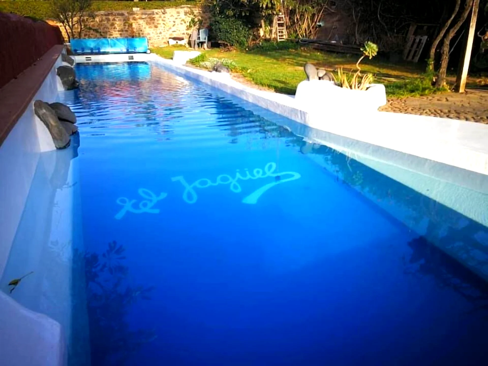 Piscina climatizada con el nombre de la villa en el fondo